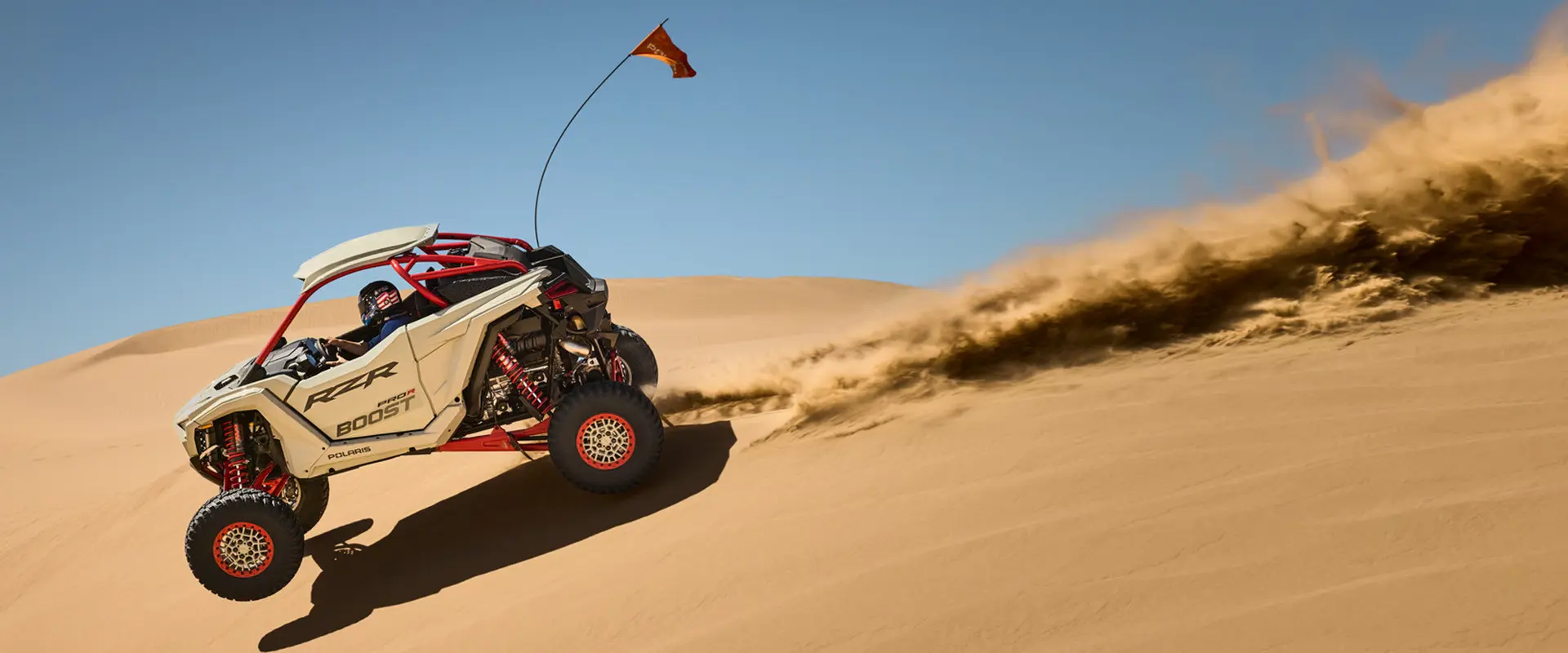 A rider in a 2027 Polaris RZR Pro R Boost Ultimate side-by-side catching air in the desert.