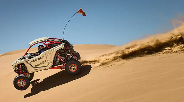 A rider in a 2027 Polaris RZR Pro R Boost Ultimate side-by-side catching air in the desert.