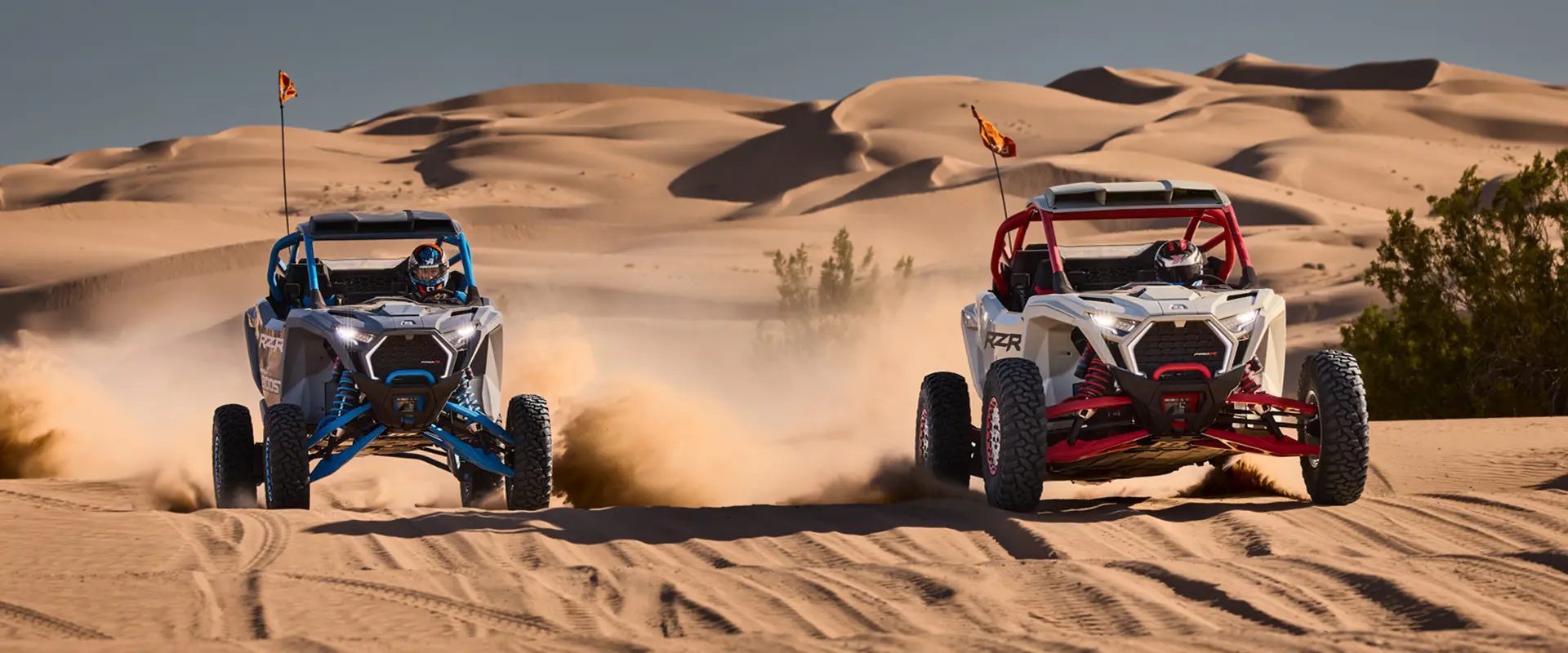 Two 2027 Polaris RZR Pro R Boost Ultimate side-by-sides driving next to each other in the desert.