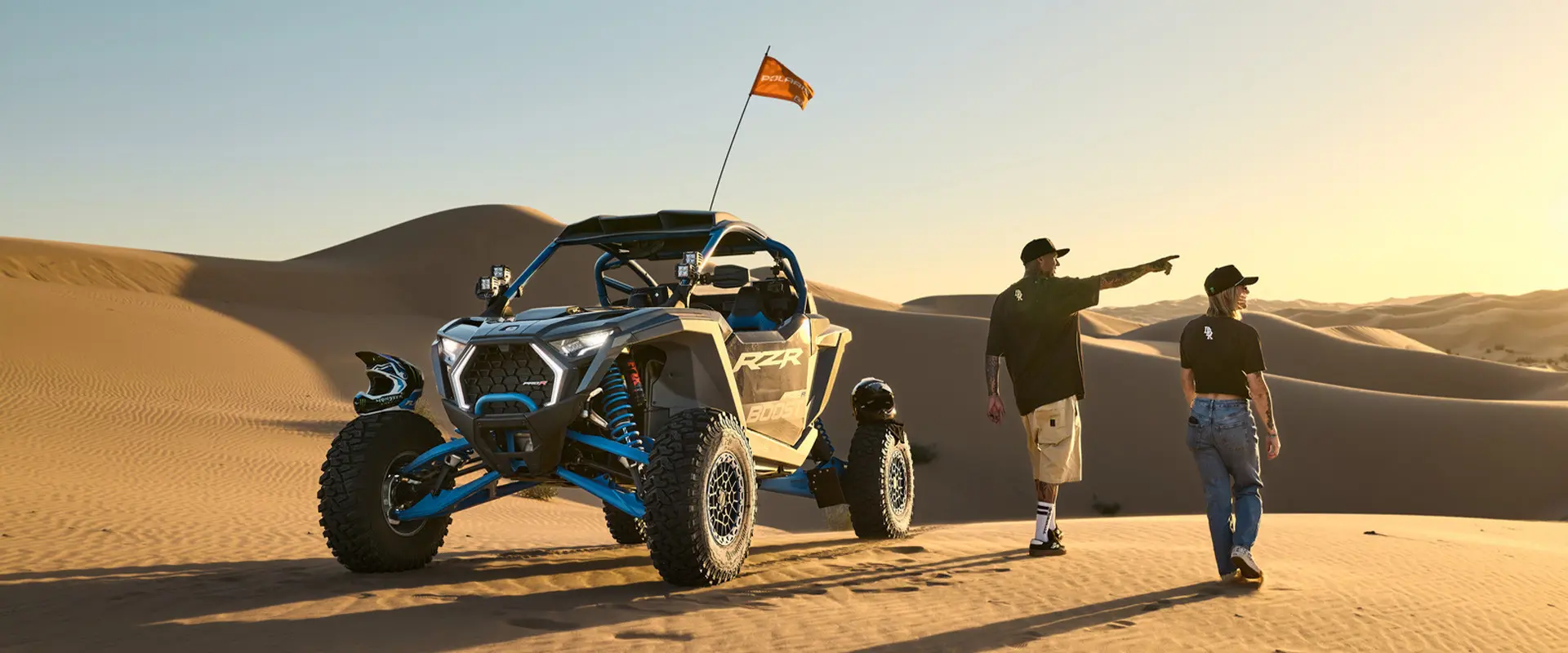 2 people pointing toward the horizon near their 2027 Polaris RZR Pro R Boost Ultimate side-by-side.