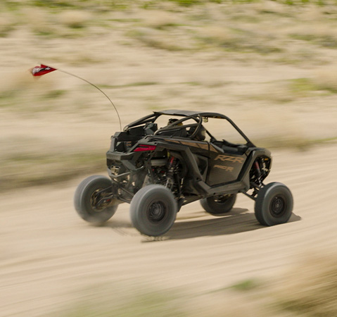 A 2027 Polaris RZR Pro R side-by-side speeding down a desert trail.