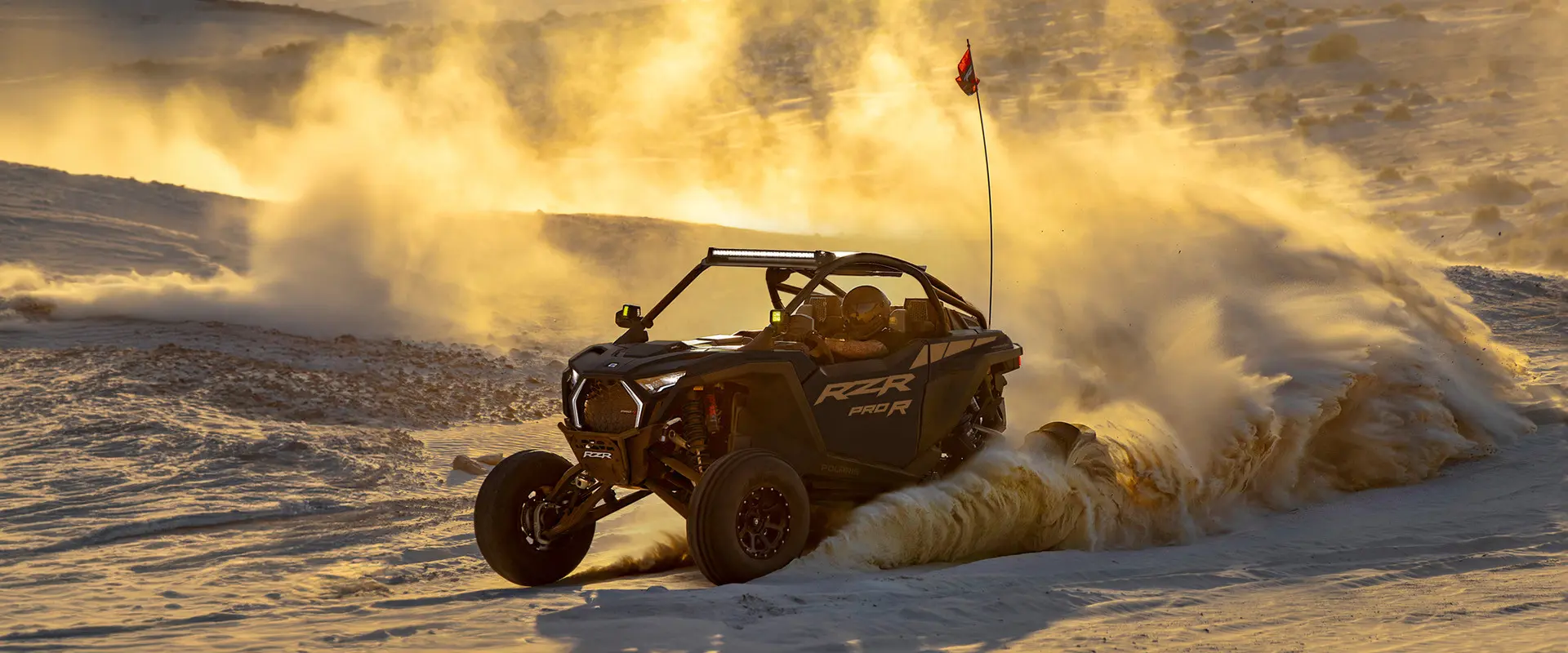 A 2027 Polaris RZR Pro R side-by-side throwing sand in the desert.