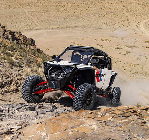 A 2027 Polaris RZR Pro S 4 side-by-side climbing a rocky hill.