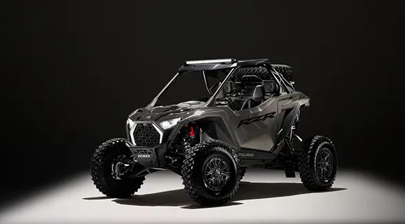 A 2027 Polaris RZR Pro S side-by-side entrenched in light in a dark room.