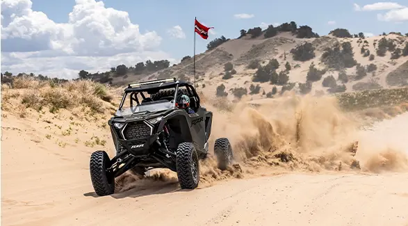 A 2027 Polaris RZR Pro S side-by-side throwing sand in the desert.