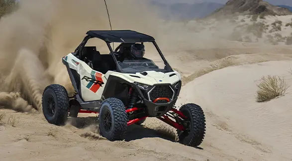 A rider in a 2027 Polaris RZR Pro S Ultimate side-by-side cruising through the desert.