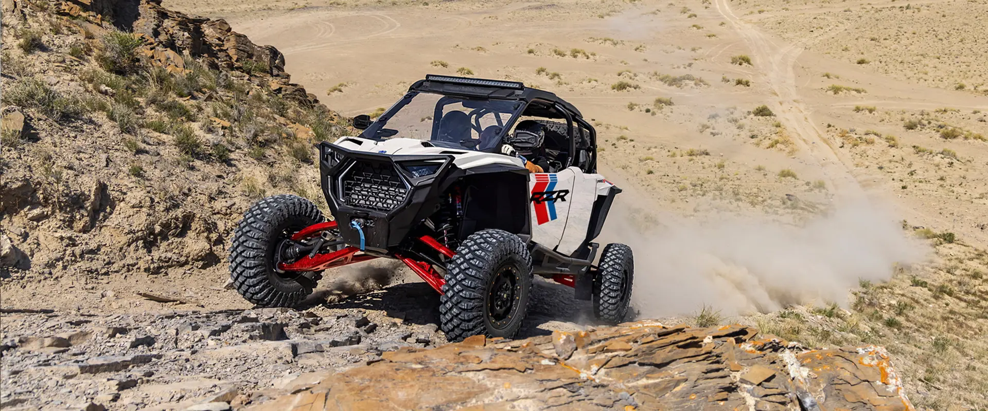 A rider in a 2027 Polaris RZR Pro S Ultimate side-by-side climbing up a rocky hill with ease.