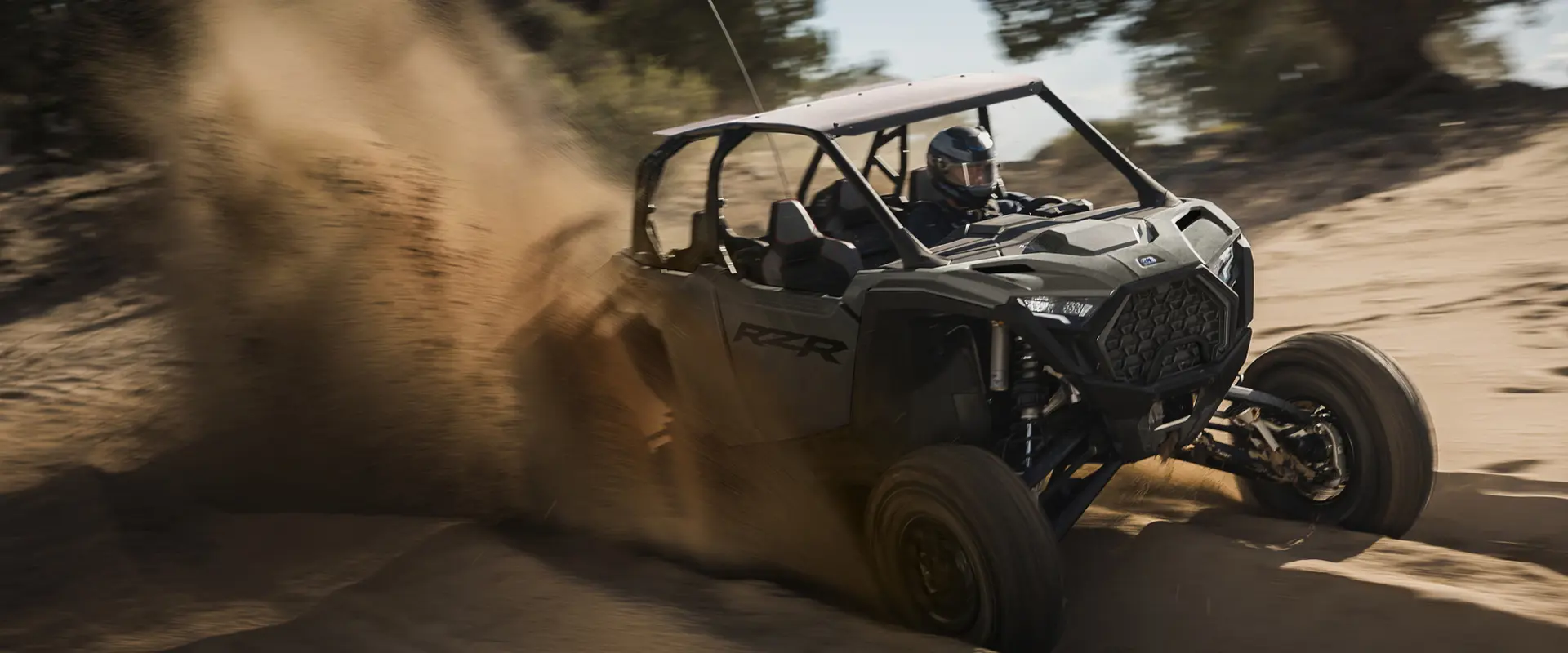 A rider in a 2027 Polaris RZR Pro S 4 side-by-side cruising down a sandy trail.
