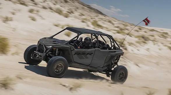 Side profile of a 2027 Polaris RZR Pro S 4 side-by-side cruising through the dunes.