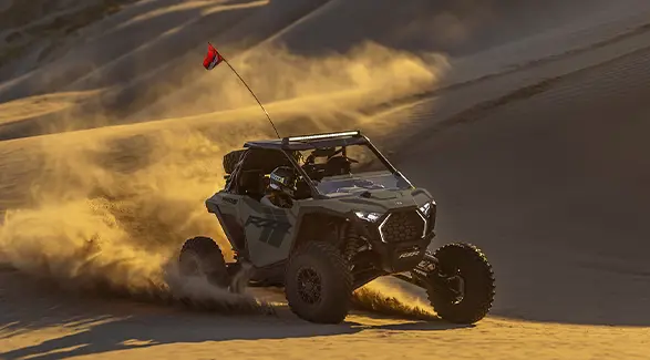 2 riders in a 2027 Polaris RZR Pro S side-by-side making a tight turn in the desert.