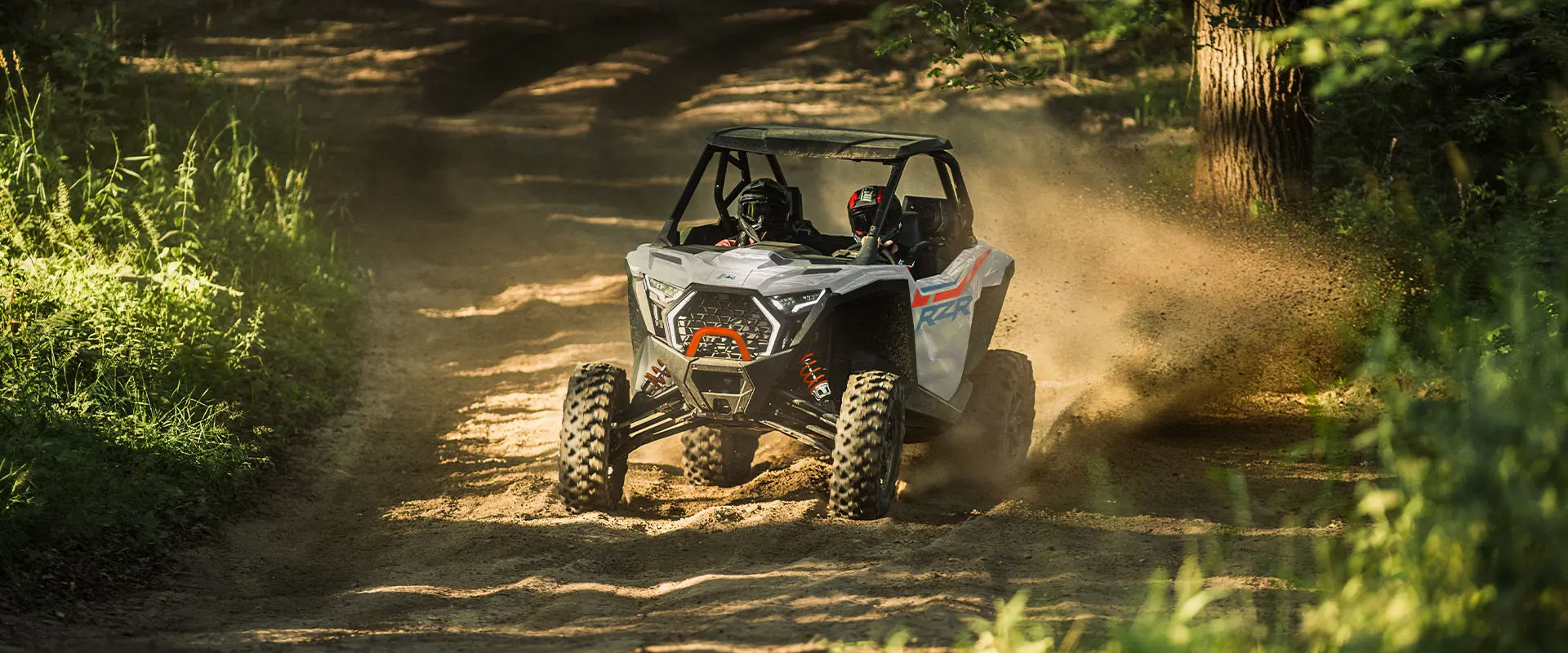 2 riders in a 2027 Polaris RZR Pro XP side-by-side throwing dirt on a dusty trail.