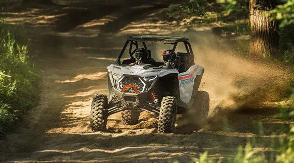 2 riders in a 2027 Polaris RZR Pro XP side-by-side throwing dirt on a dusty trail.