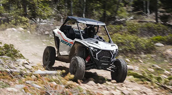 A rider in a 2027 Polaris RZR Pro XP side-by-side cruising down a rough trail.