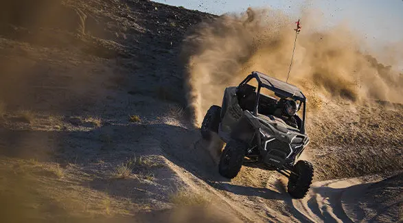 A 2027 Polaris RZR Pro XP side-by-side taking a tight corner on a sandy trail.