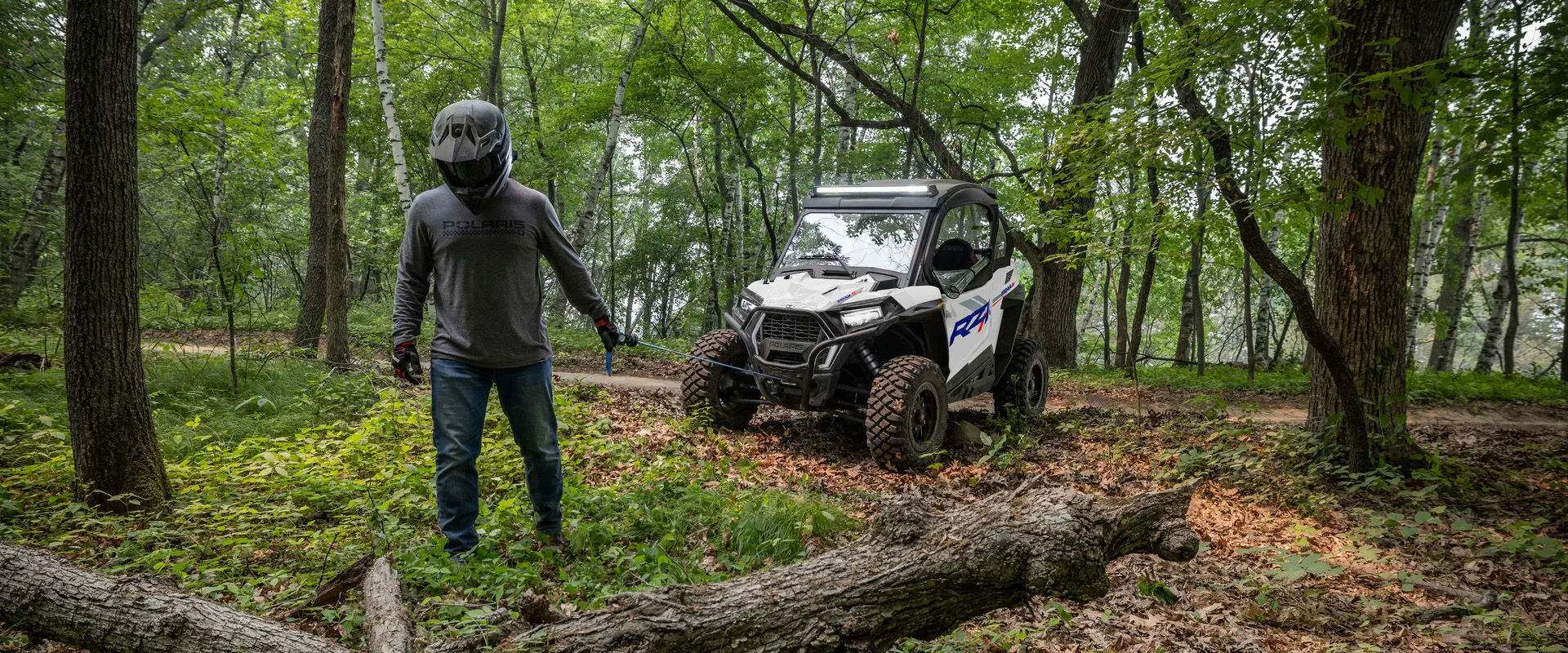 A person using the winch from the front end of a 2027 Polaris RZR Trail S side-by-side.