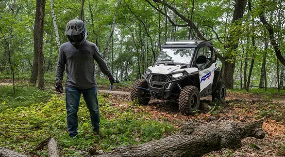 A person using the winch from the front end of a 2027 Polaris RZR Trail S side-by-side.
