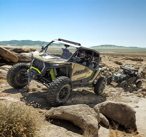 A 2027 Polaris RZR XP S 4 side-by-side crawling over rocky terrain with ease using 32-inch tires.