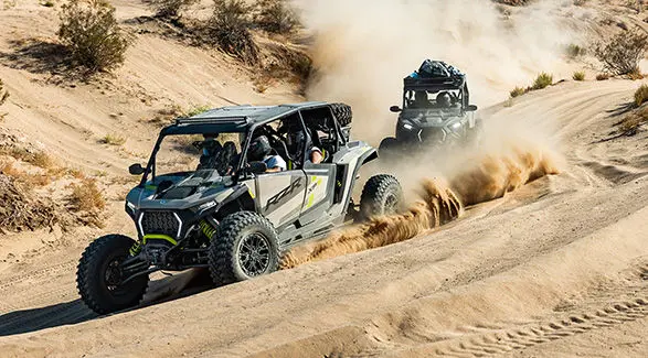 4 riders in a 2027 Polaris RZR XP S 4 side-by-side cruising through the dunes.