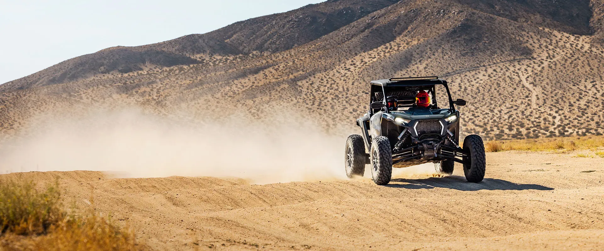 2 riders cruising through the dunes in their 2027 Polaris RZR XP S side-by-side.