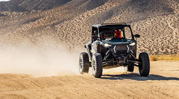 2 riders cruising through the dunes in their 2027 Polaris RZR XP S side-by-side.