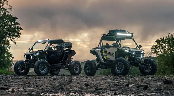 Two 2027 Polaris RZR XP S side-by-sides with lights illuminated.
