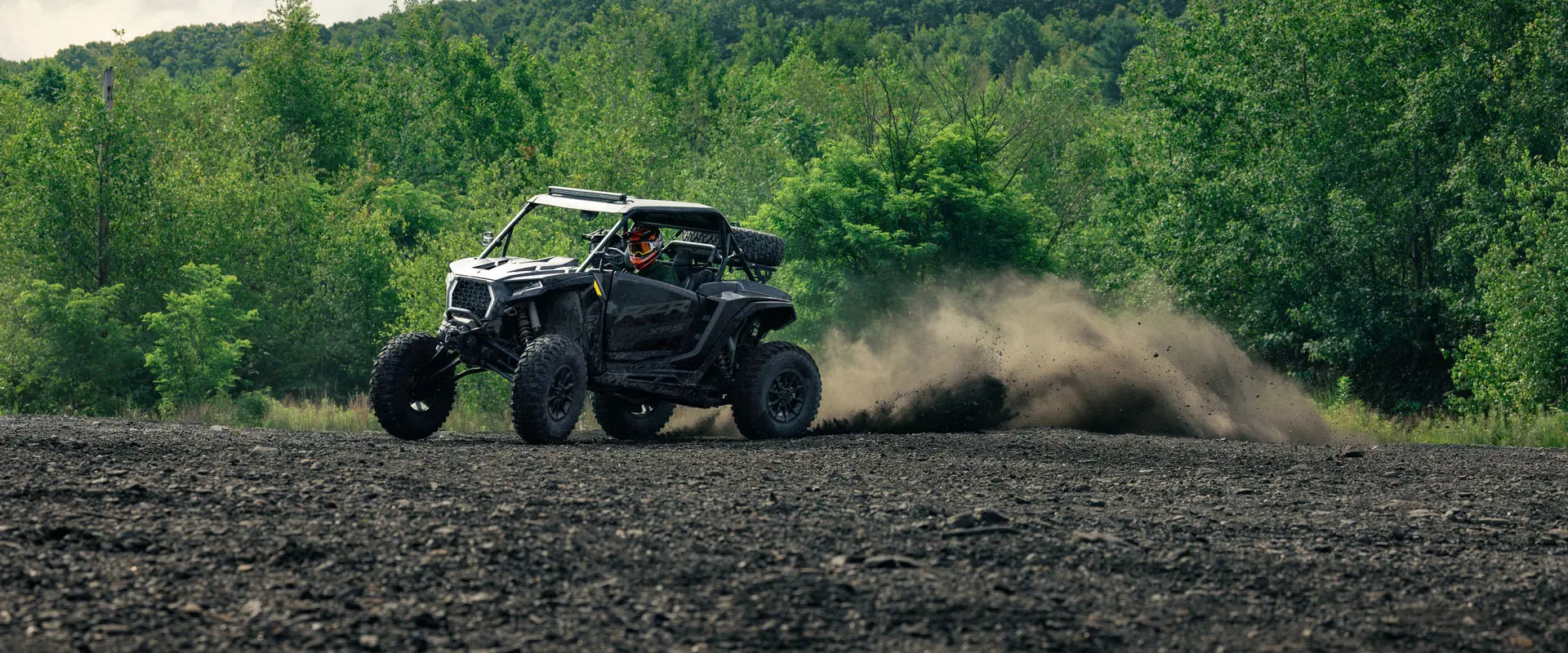 A 2027 Polaris RZR XP S side-by-side throwing dirt on a rough trail.