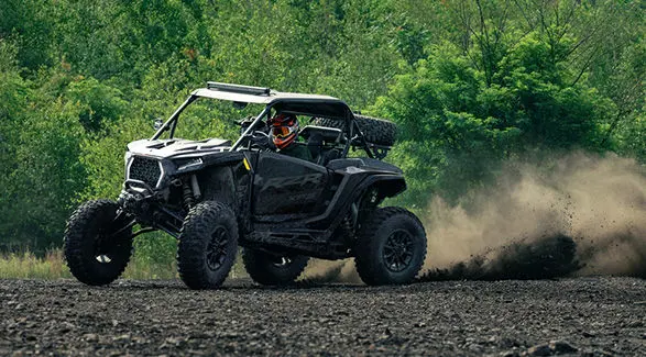 A 2027 Polaris RZR XP S side-by-side throwing dirt on a rough trail.