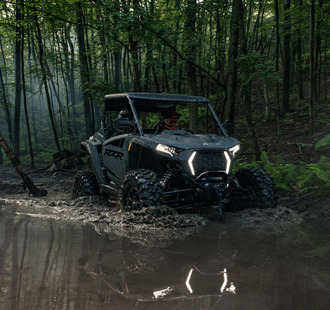A 2027 Polaris RZR XP Ultimate side-by-side powering through a mudhole with ease.