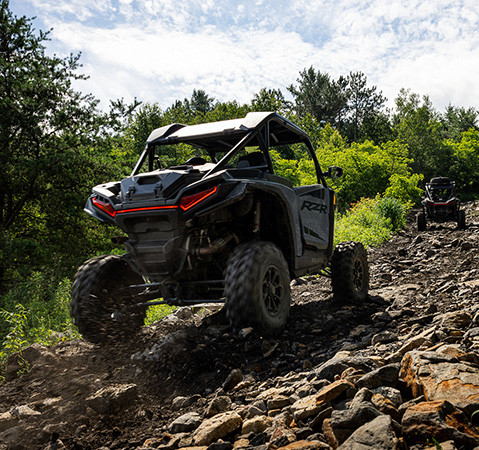 3 2027 Polaris RZR XP Ultimate side-by-sides driving over rough terrain with ease.