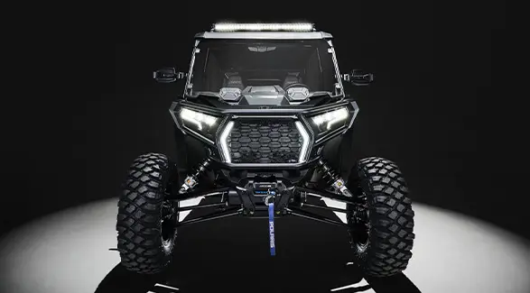 Front end view of a 2027 Polaris RZR XP 4 Ultimate SxS with illuminated headlights.