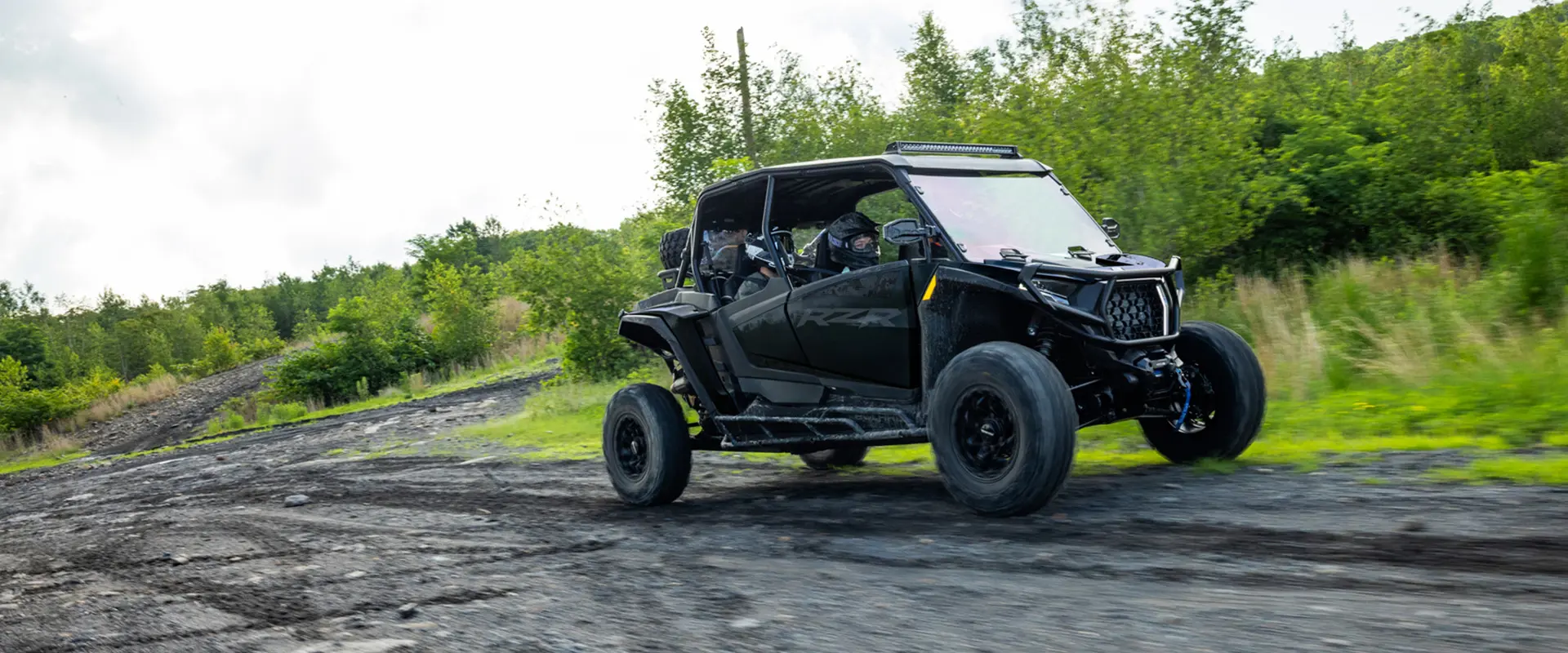 A 2027 Polaris RZR XP 4 Ultimate SxS cruising down a trail.