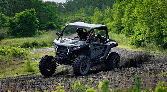 2 riders in a 2027 Polaris RZR XP Ultimate SxS taking a tight corner with ease.