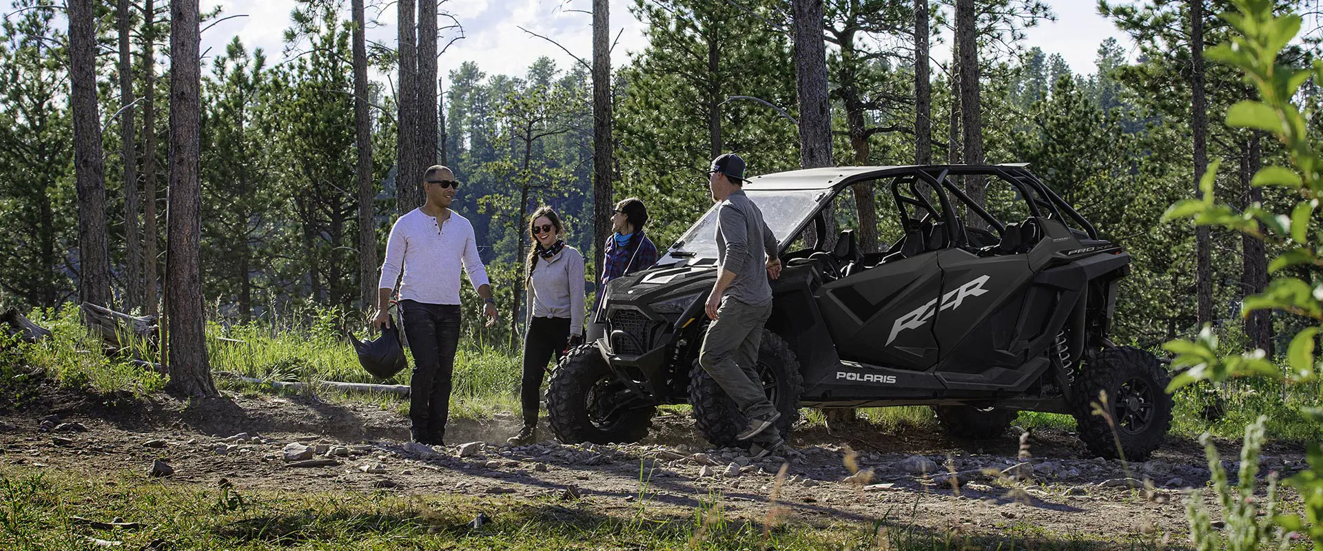 people hanging out after a ride in their polaris rzr pro xp 4 side by side