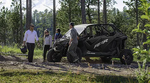 people hanging out after a ride in their polaris rzr pro xp 4 side by side