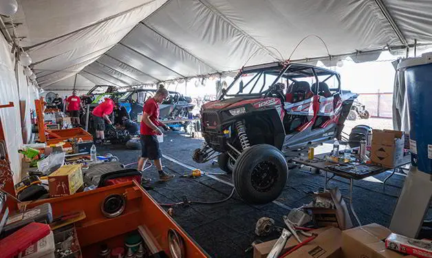 mecánico cambiando llantas en polaris rzr side-by-side