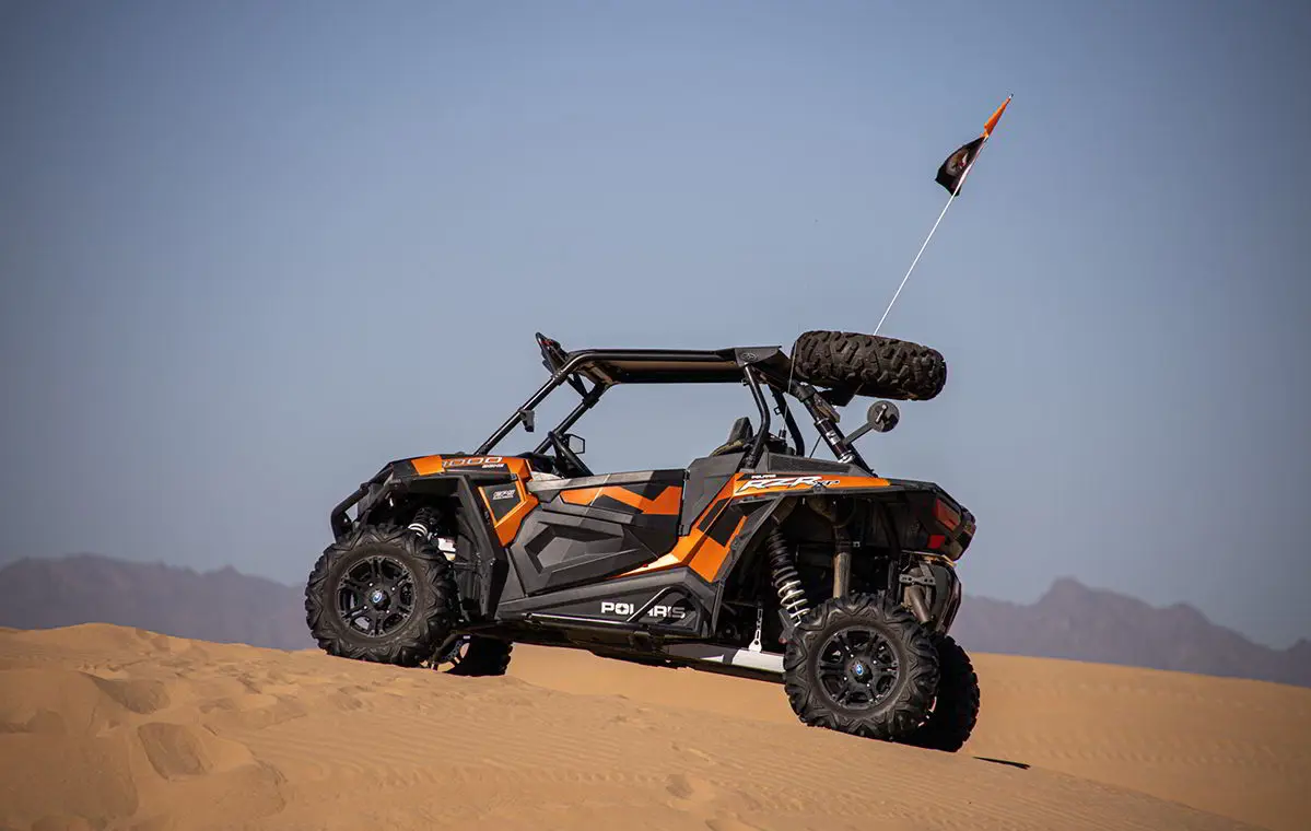 perfil lateral de un rzr xp 1000 estacionado sobre una duna