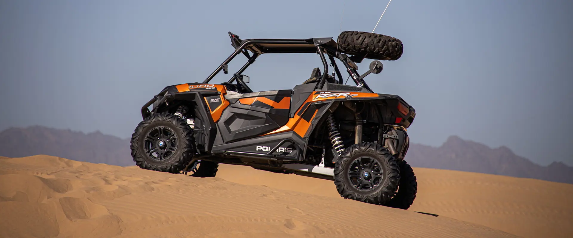 perfil lateral de un rzr xp 1000 estacionado sobre una duna