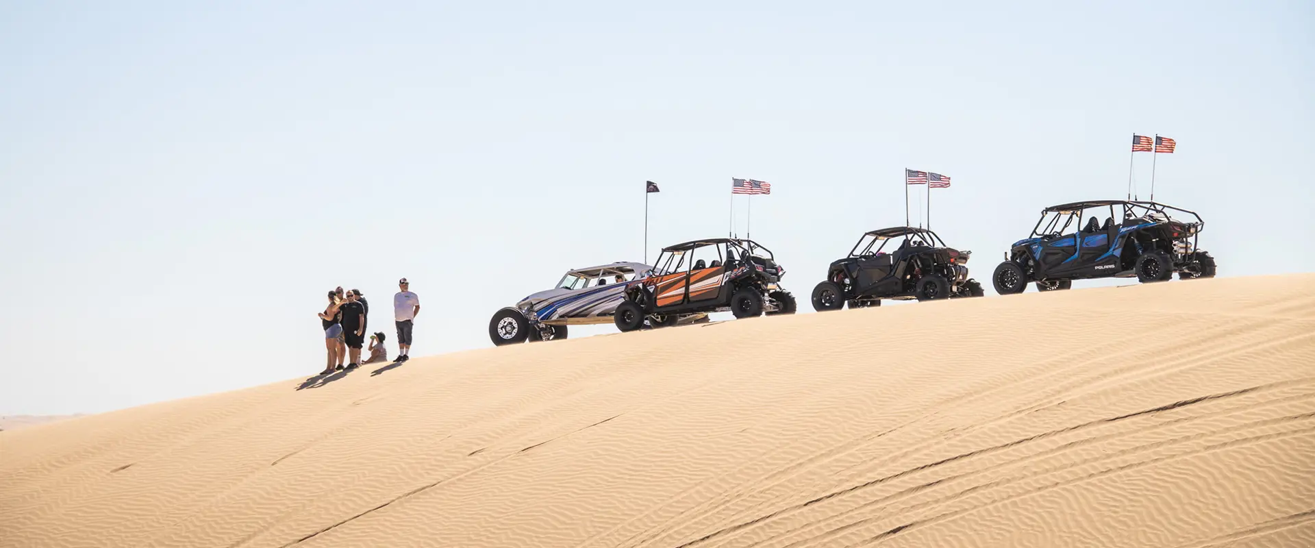 4 polaris rzr side-by-side estacionados sobre una duna