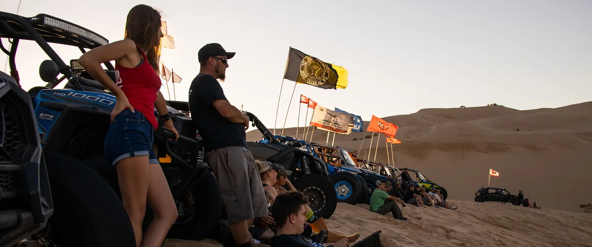 personas relajándose junto a sus side-by-side rzr en camp rzr
