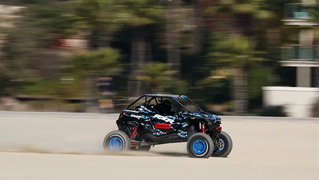 El Hoonigan RZR pro R navegando por la arena en una playa
