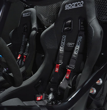 Inside view of the ergonomic carbon kevlar Sparco® seats, harnesses and steering wheel with integrated controls of the Polaris RZR Pro R Factory Edition.