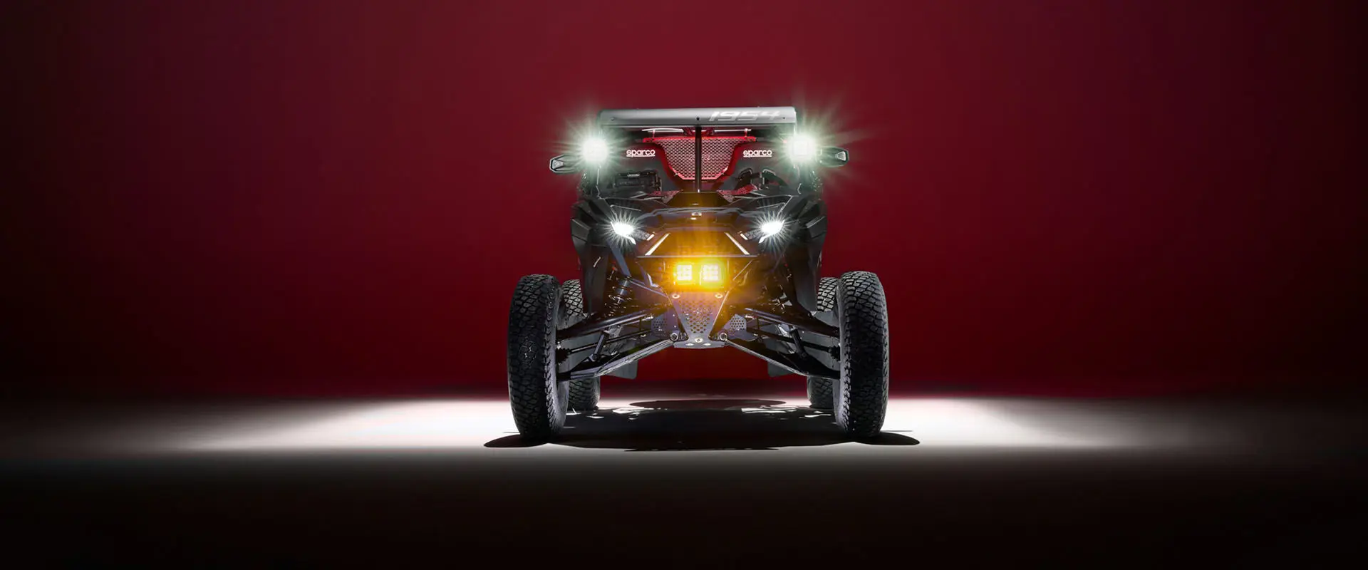 Front view of a Polaris RZR Pro R Factory Edition with the flashlights turn on.