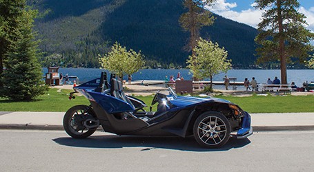 Slingshot azul con árboles, un lago y una montaña en el fondo