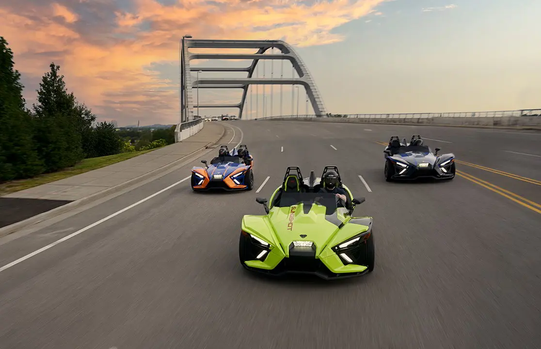 Three Slingshot vehicles riding on the road