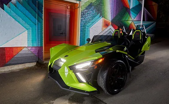 Slingshot R LE vehicle parked next to four people chatting