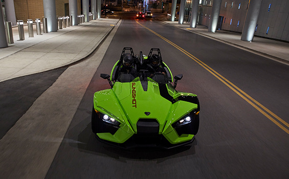 A Slingshot R vehicle riding on a road during the night