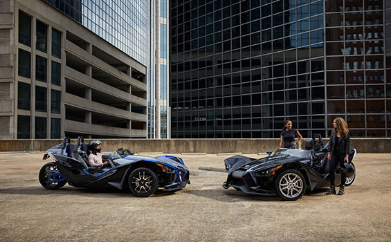 Three Slingshot vehicles riding on a road