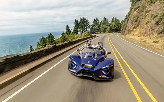 perfil lateral de una motocicleta de tres ruedas polaris slingshot r en una carretera