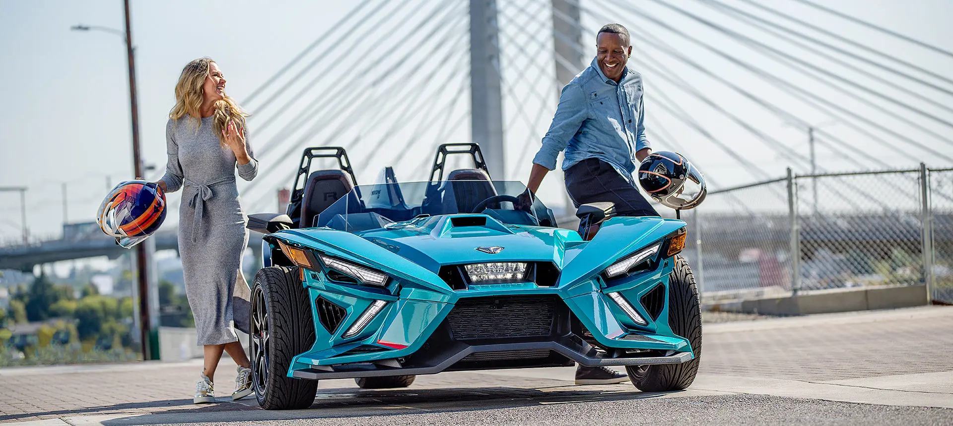 conductor y pasajero saliéndose de una motocicleta de tres ruedas polaris slingshot r