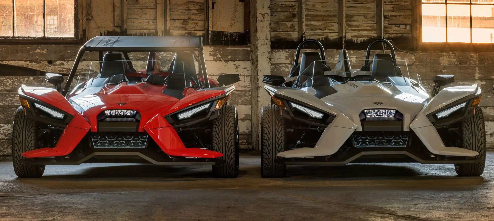 front view of two polaris slingshot's parked in a garage